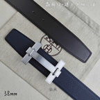 Blue and black leather belts with silver-tone H buckle, close-up side view.