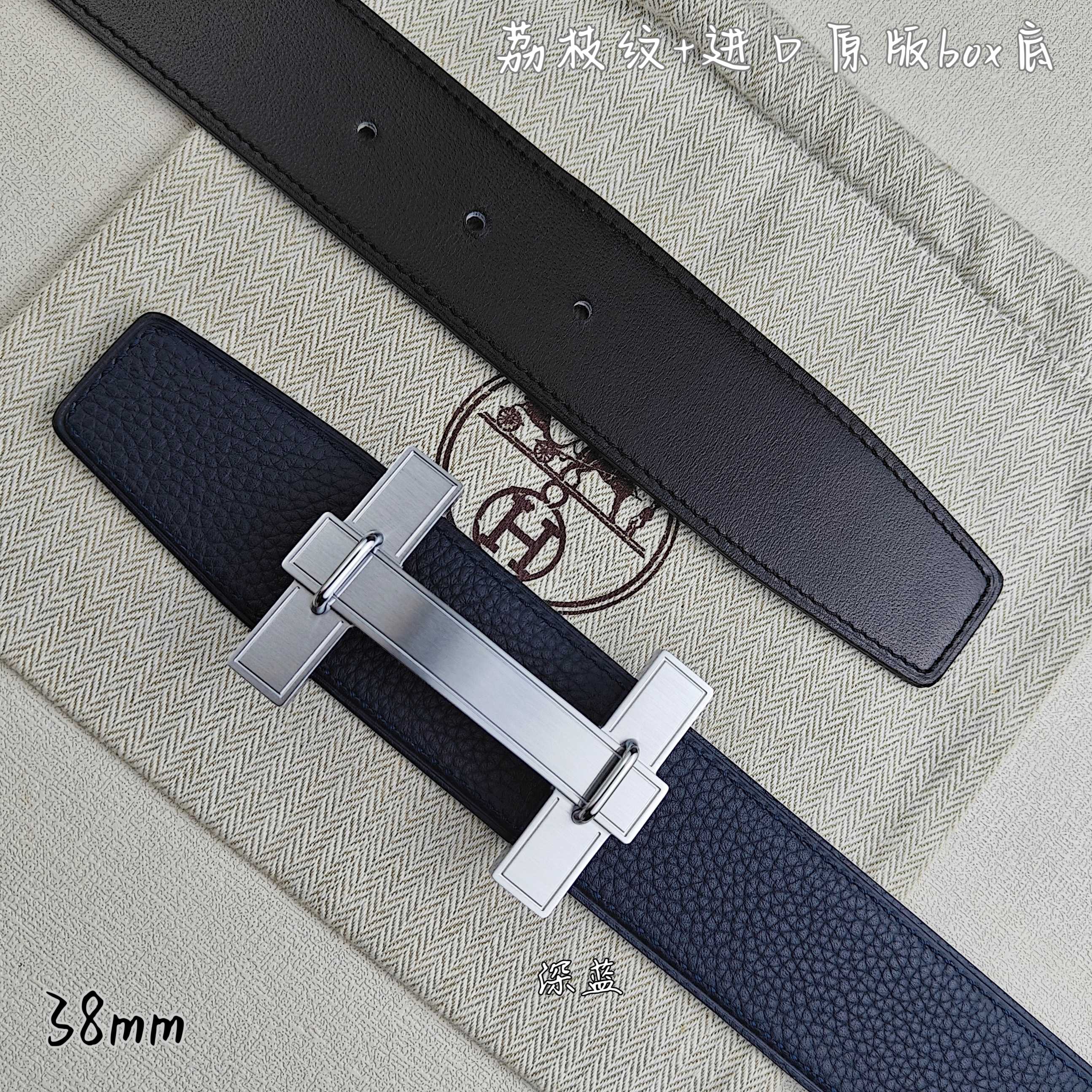 Blue and black leather belts with silver-tone H buckle, close-up side view.