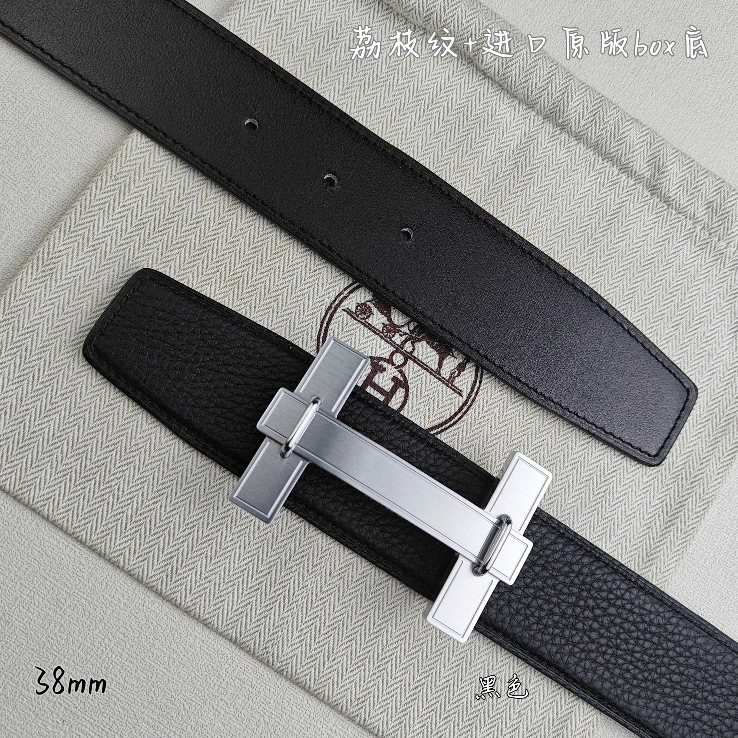Leather belt detail: silver-tone H buckle on dark strap