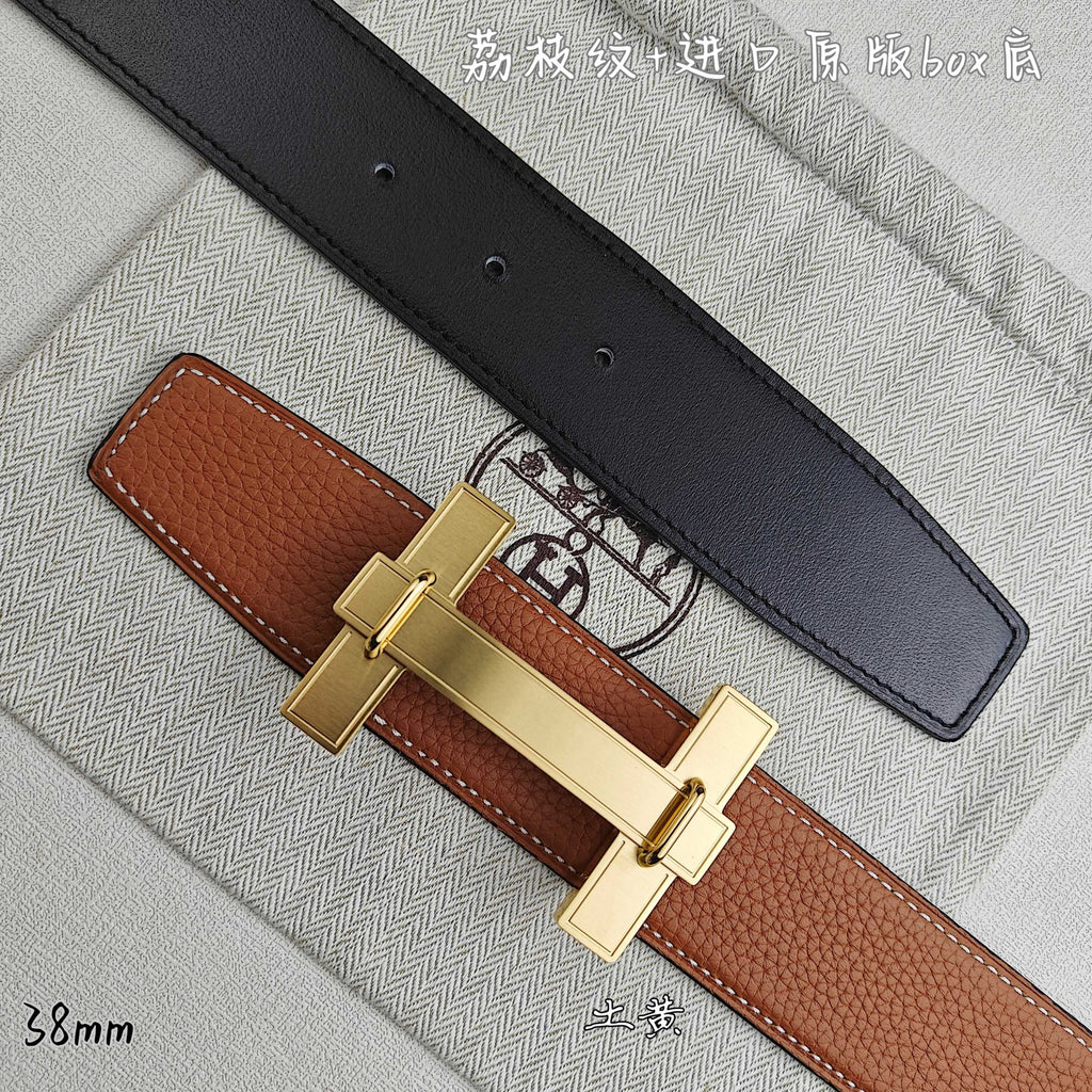 Hermes belt with tan leather and black underside, gold-tone buckle detail.