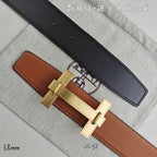 Hermes belt with tan leather and black underside, gold-tone buckle detail.