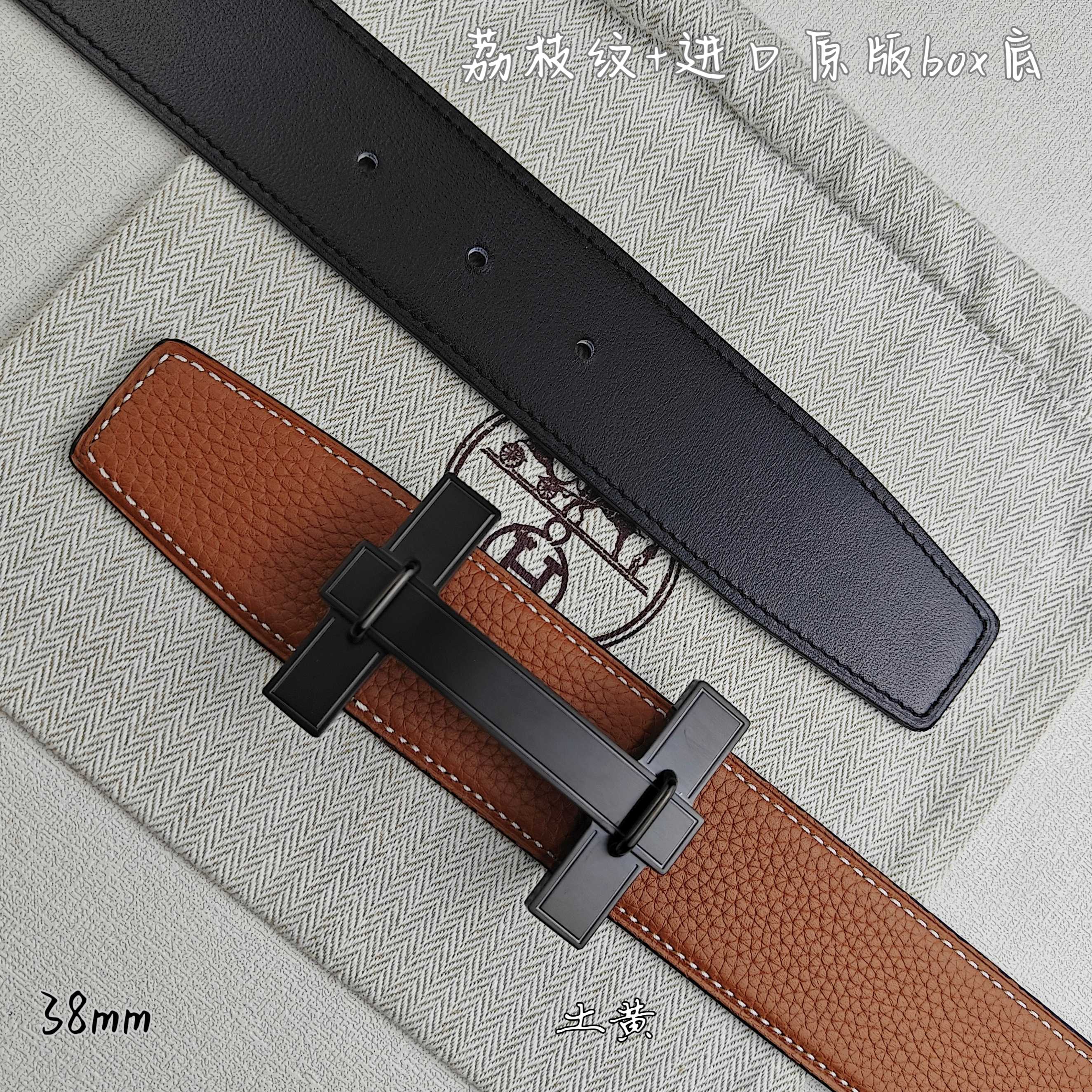 Hermes belt with tan leather and black underside, dark-tone buckle detail.