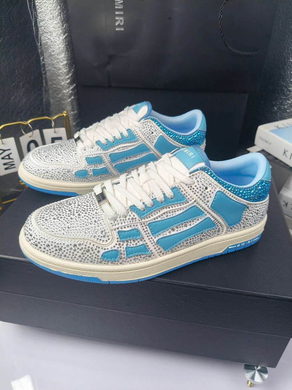 Pair of white and blue low-top sneakers with lace-up closure and textured panels