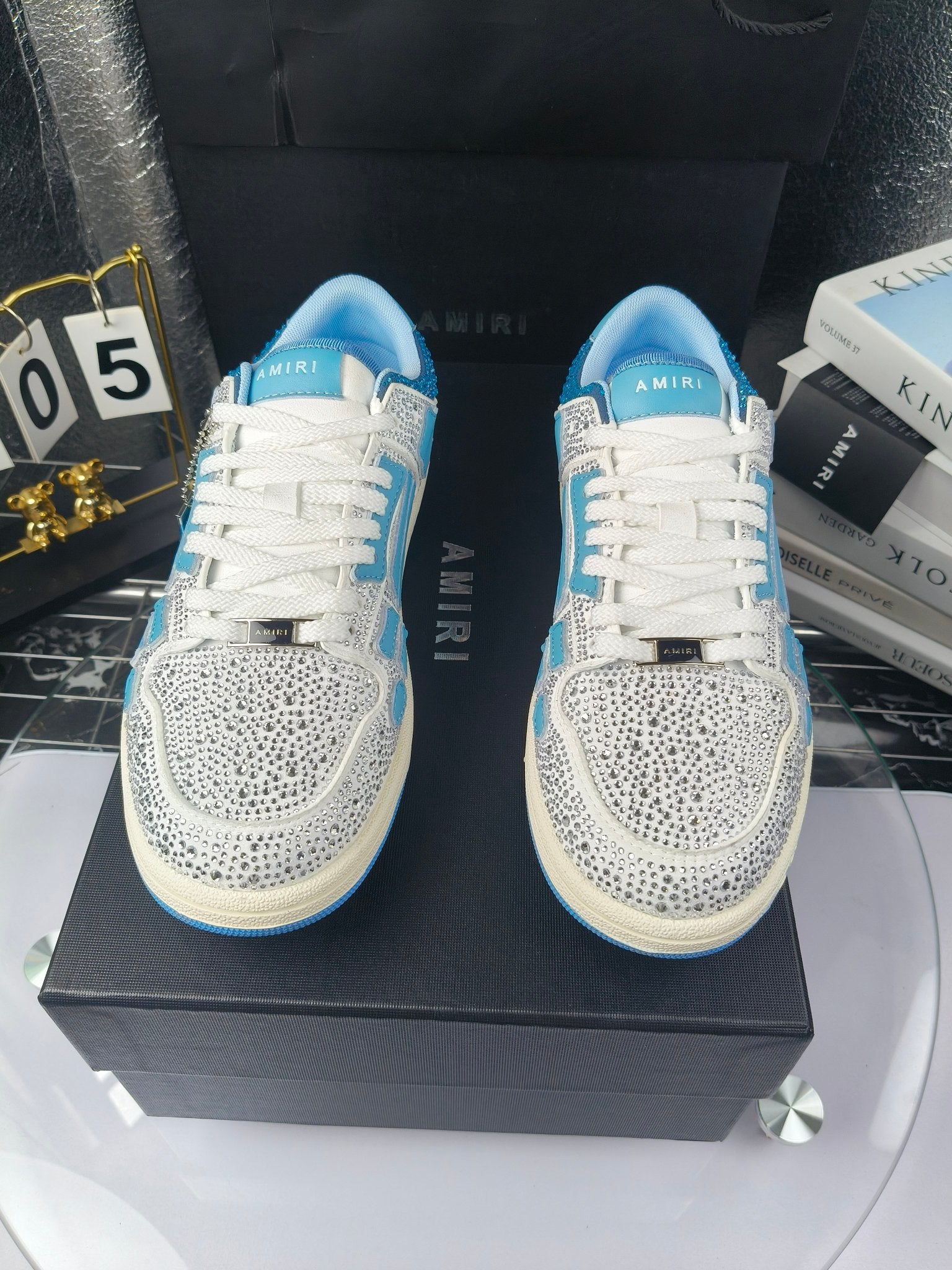 Front view of white and blue lace-up sneakers with textured speckled toe