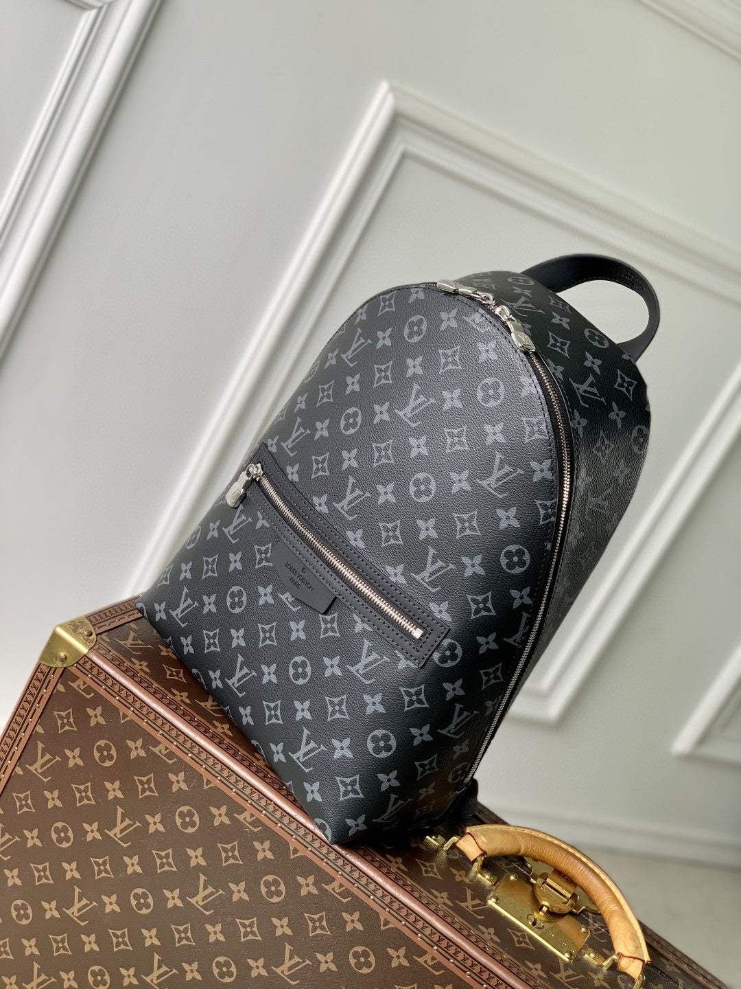 Louis Vuitton monogram canvas backpack, side view with silver zipper and rounded top