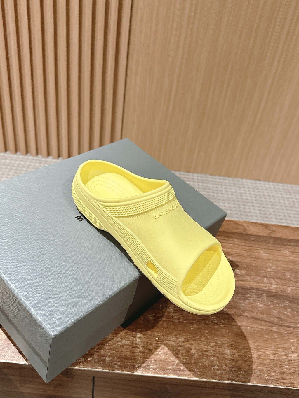 Balenciaga yellow slide sandal on gray box, open toe and textured footbed