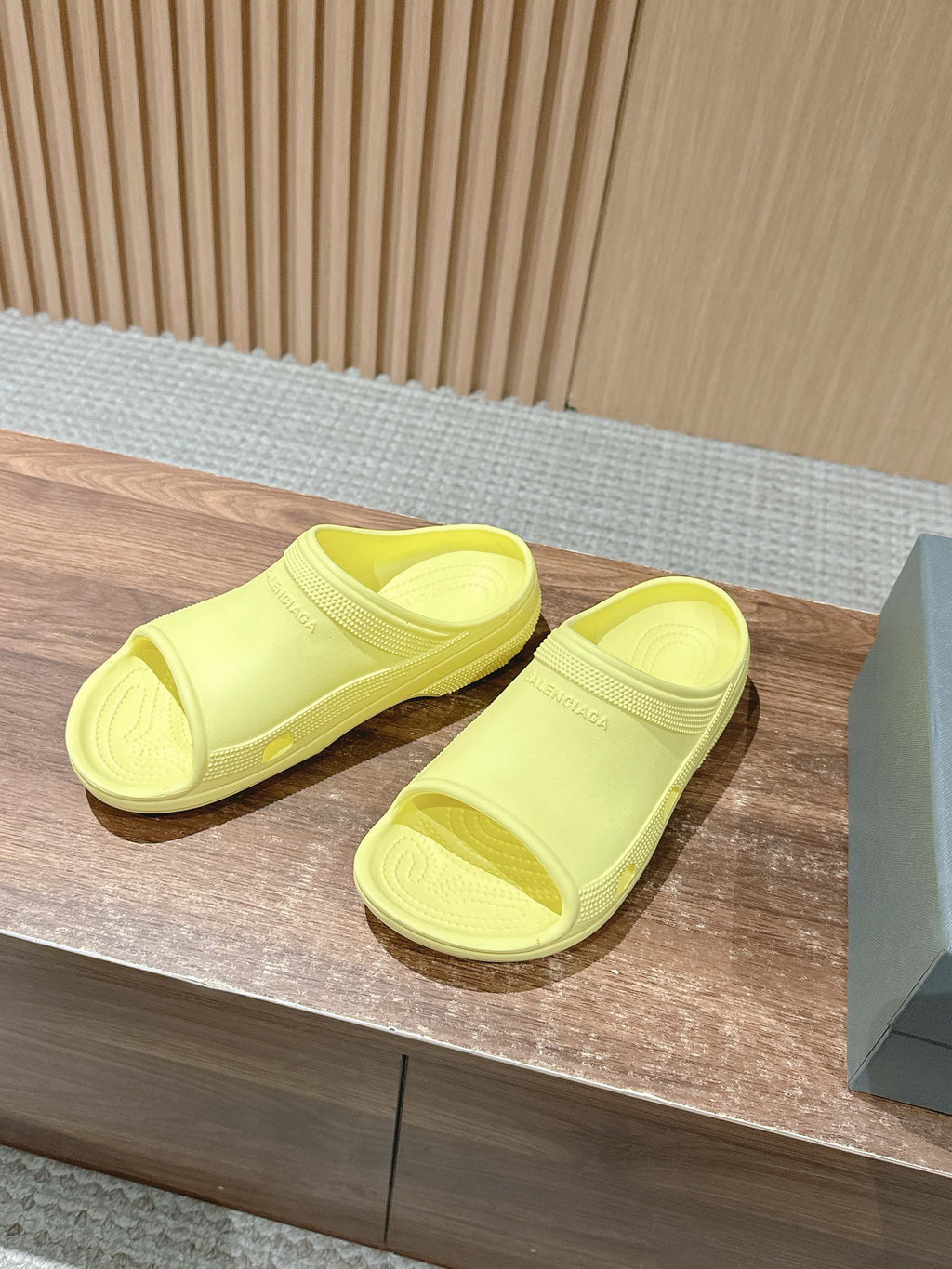 Balenciaga neon yellow slide sandals, two sandals side by side on display