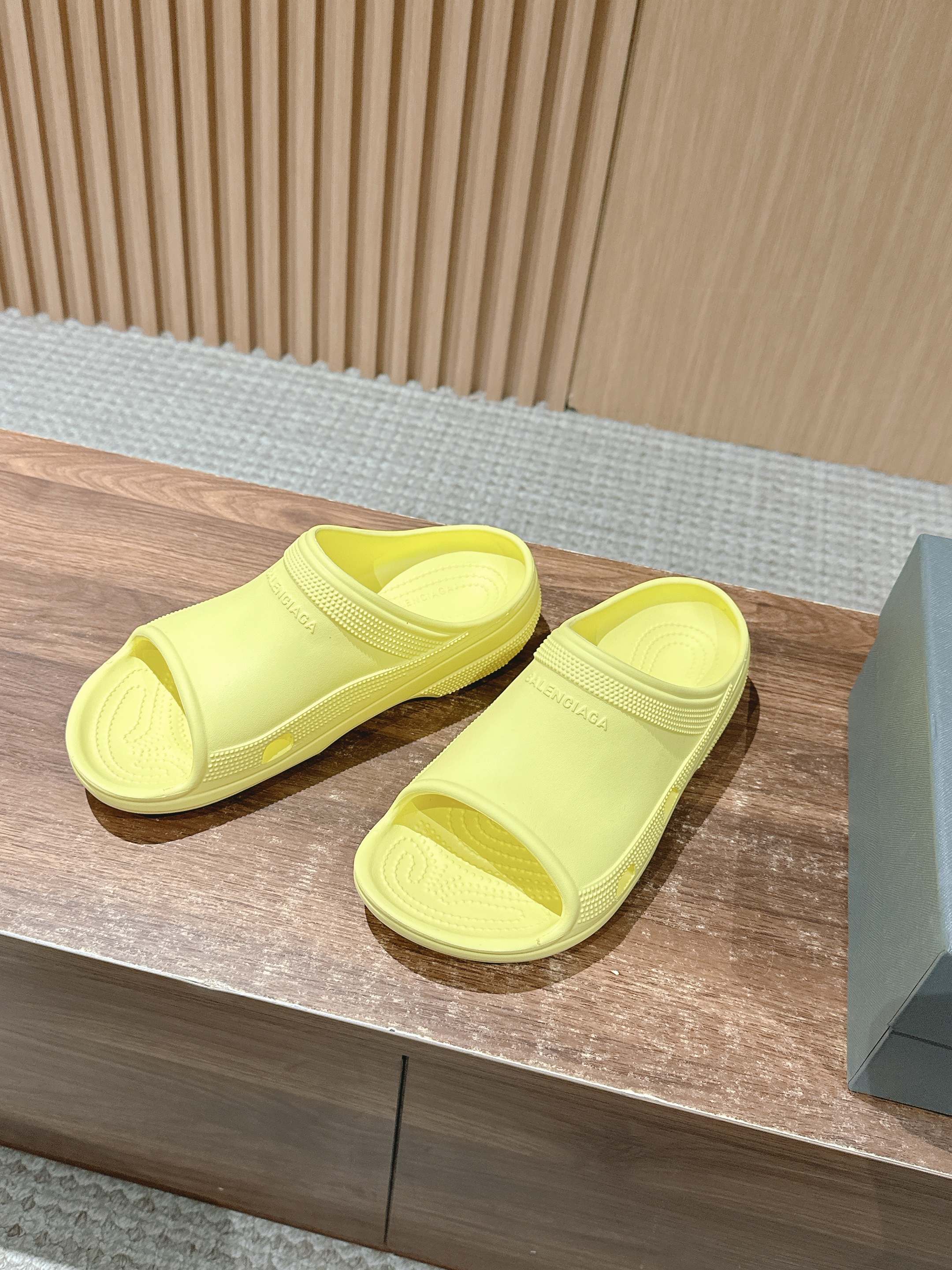 Balenciaga neon yellow slide sandals, two sandals side by side on display