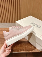Pink textured leather-look sneaker with lace-up front and white rubber sole