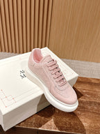 Pink Alexander McQueen lace-up sneaker with white rubber sole, 3/4 view.