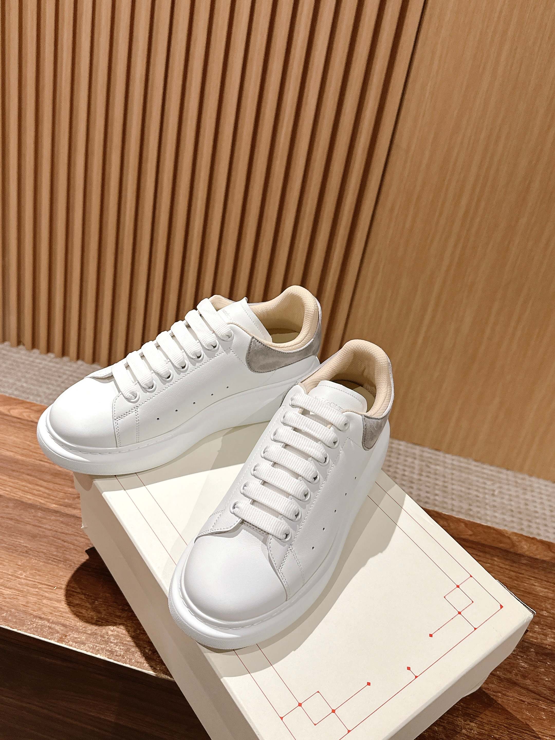 Alexander McQueen white low-top sneakers with gray-trimmed tongue and lace-up closure
