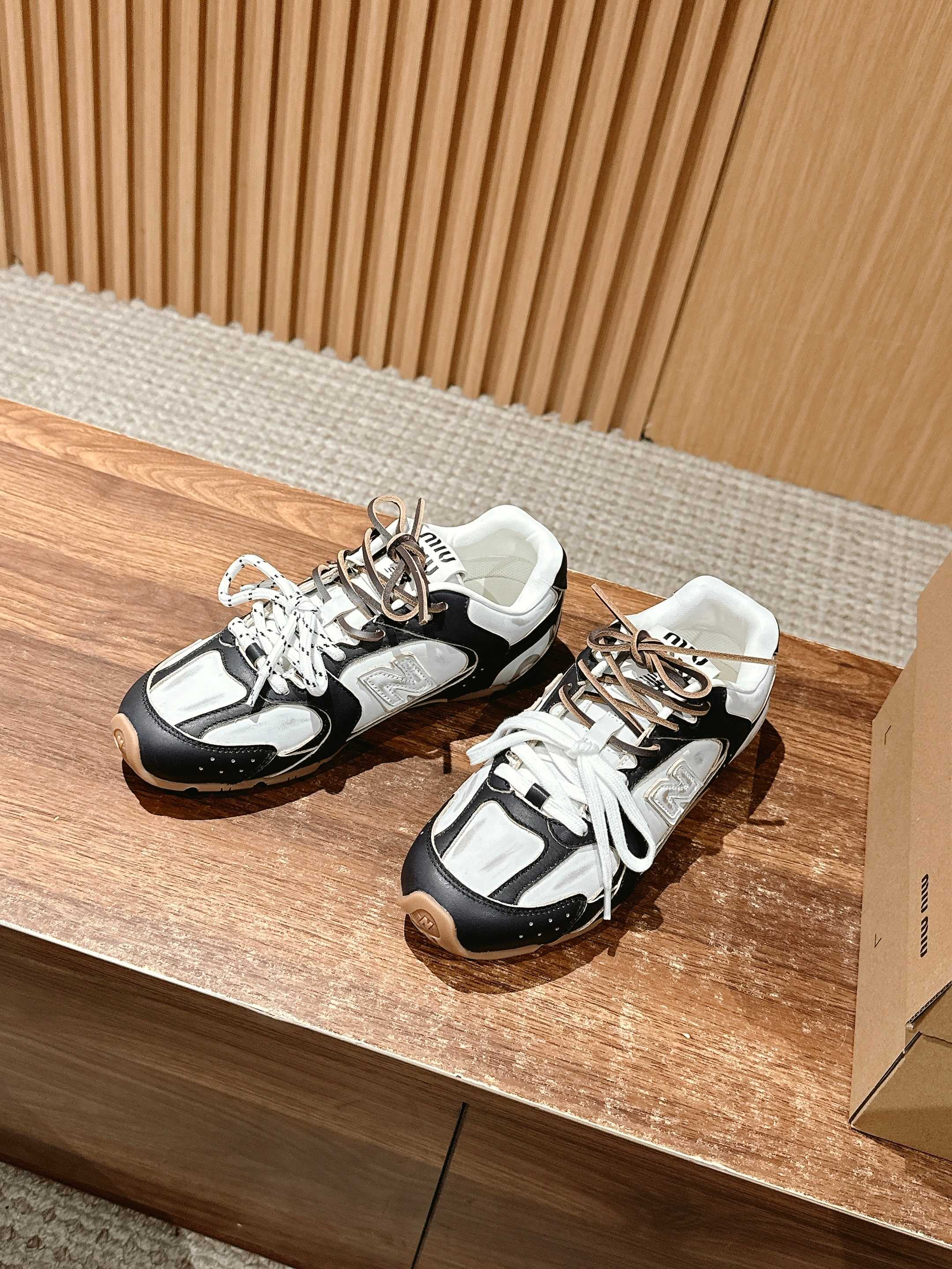 Pair of black and white unisex sneakers with white laces and contrast panels