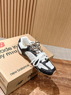 Black and white unisex lace-up sneakers resting on shoeboxes