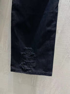 Balenciaga dark denim jeans with heavy frayed rip detail on the leg