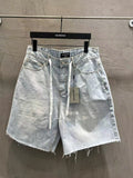 Light-wash denim shorts with drawstring tie, front pockets, and frayed hem
