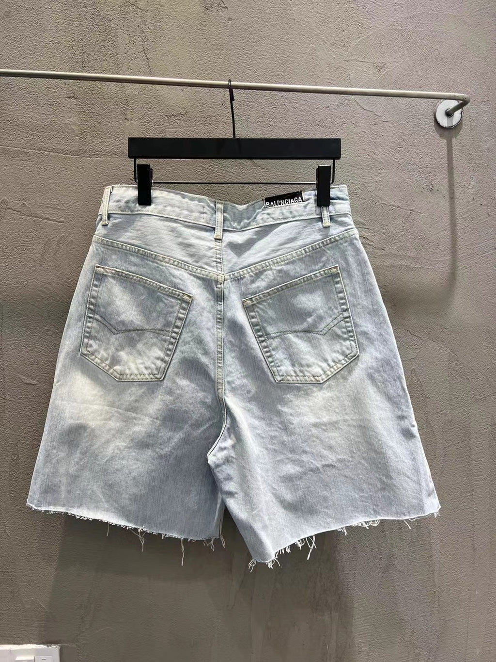 Light-wash denim shorts with stitched front pockets and frayed cuffs