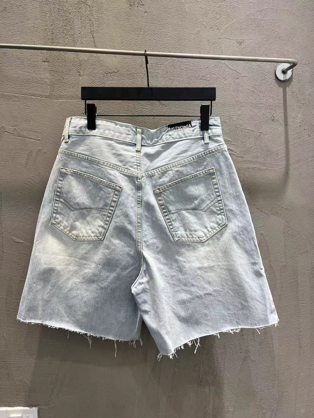 Light-wash denim shorts with stitched front pockets and frayed cuffs