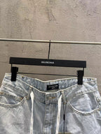 Light-wash denim shorts showing waistband, button closure, and drawstring
