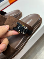 Close-up of brown Dior slide sandal with suede strap and silver buckle hardware