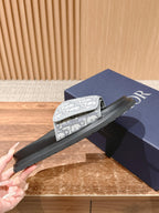Dior slide sandals held by hand, black sole and white logo-print strap