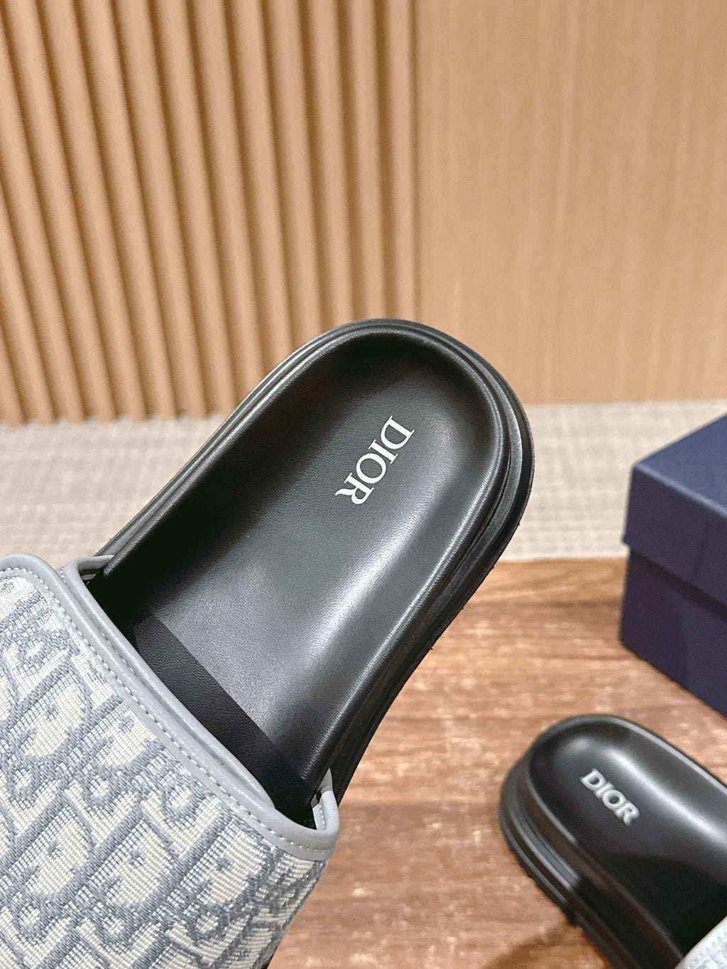 Dior slide sandal close-up, black footbed with Dior branding and logo strap