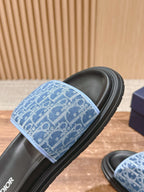 Blue monogram slide sandal close-up with black rubber sole