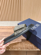 Dior slide sandal with beige Oblique strap, black footbed, and thick sole