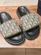 Black Dior slide sandals with beige Oblique patterned straps and embossed Dior footbeds