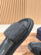 Dior slide sandals close-up of dark logo-pattern strap on black slide