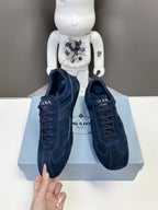 Navy suede lace-up sneakers with stitched overlays and branded tongue tag
