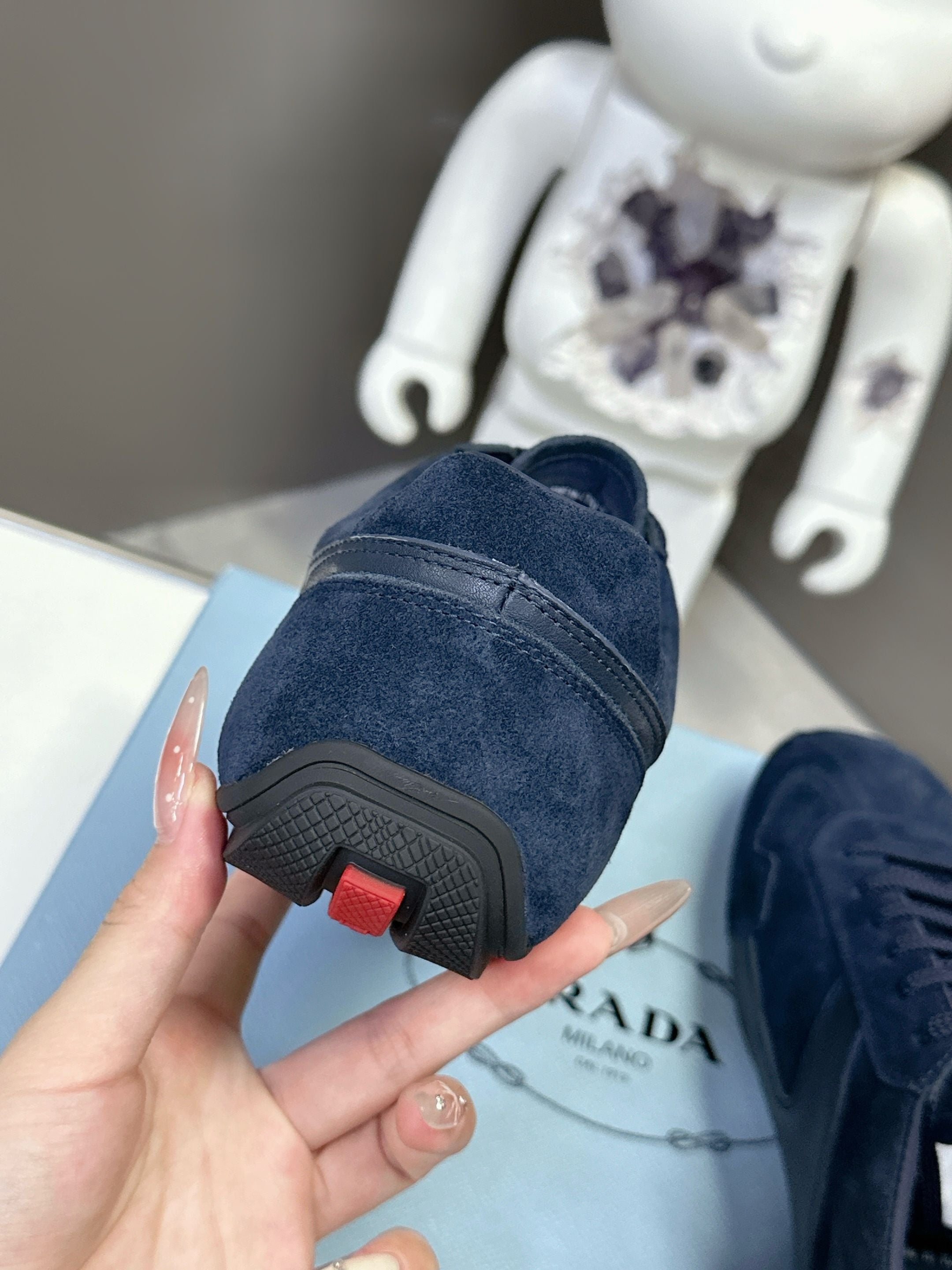 Navy suede sneakers with treaded outsole and red heel accent