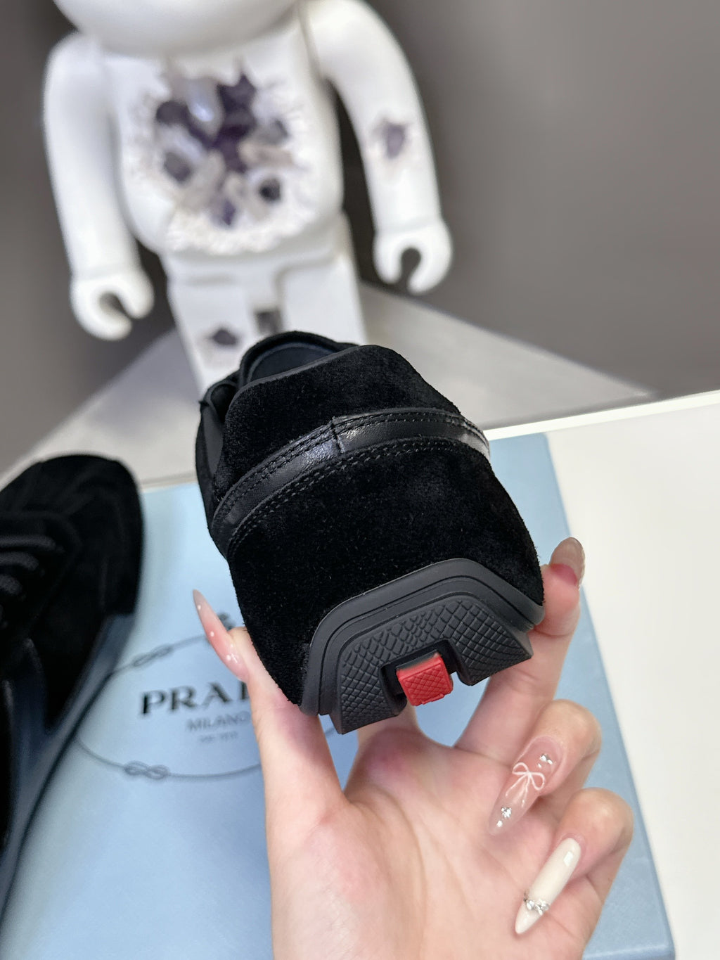 Black Prada unisex sneaker sole detail, red accent on rubber heel