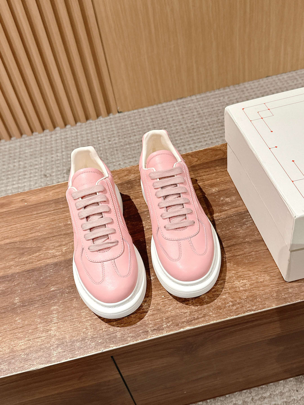 Pair of pink lace-up low-top sneakers with white rubber midsoles
