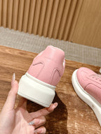 Pink leather sneaker heel with white rubber sole and lace-up upper