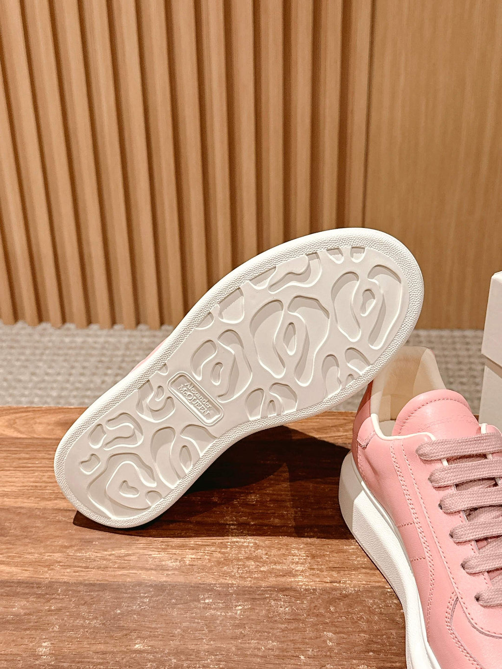 Pink sneaker outsole with tread pattern and white rubber edge