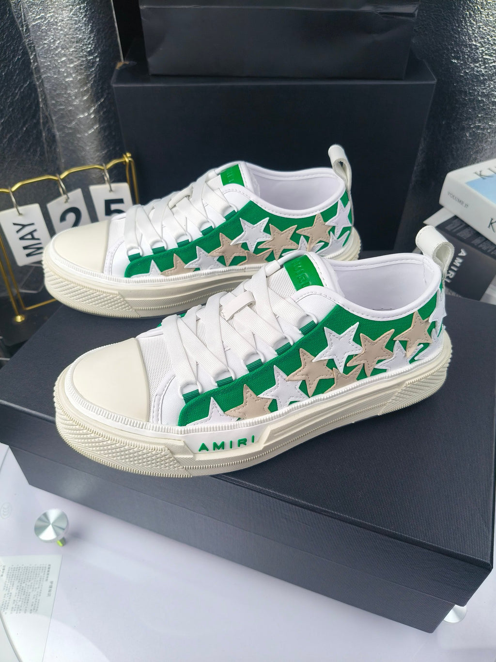 Pair of white low-top sneakers with green star print and white laces, Amiri branding