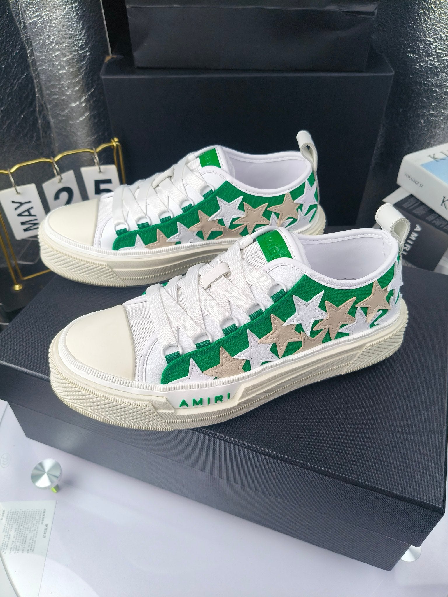 Pair of white low-top sneakers with green star print and white laces, Amiri branding
