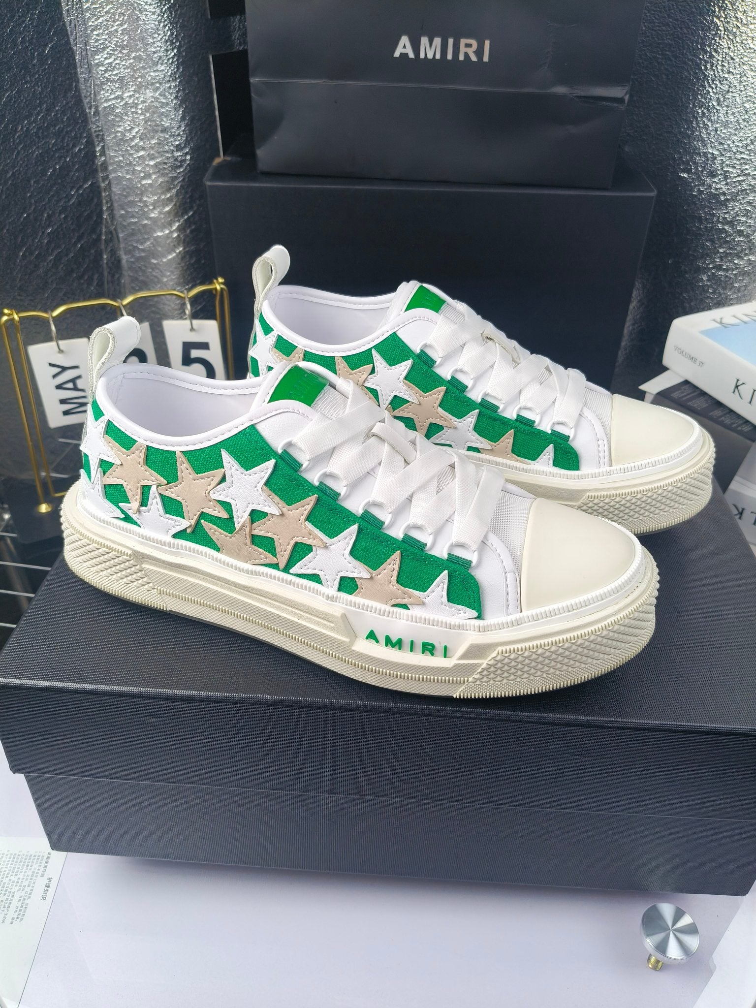 White low-top sneakers with green star motif and white laces, Amiri logo on sole