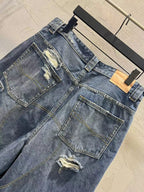 Distressed blue denim shorts with patch pockets, frayed seams, and belt loops