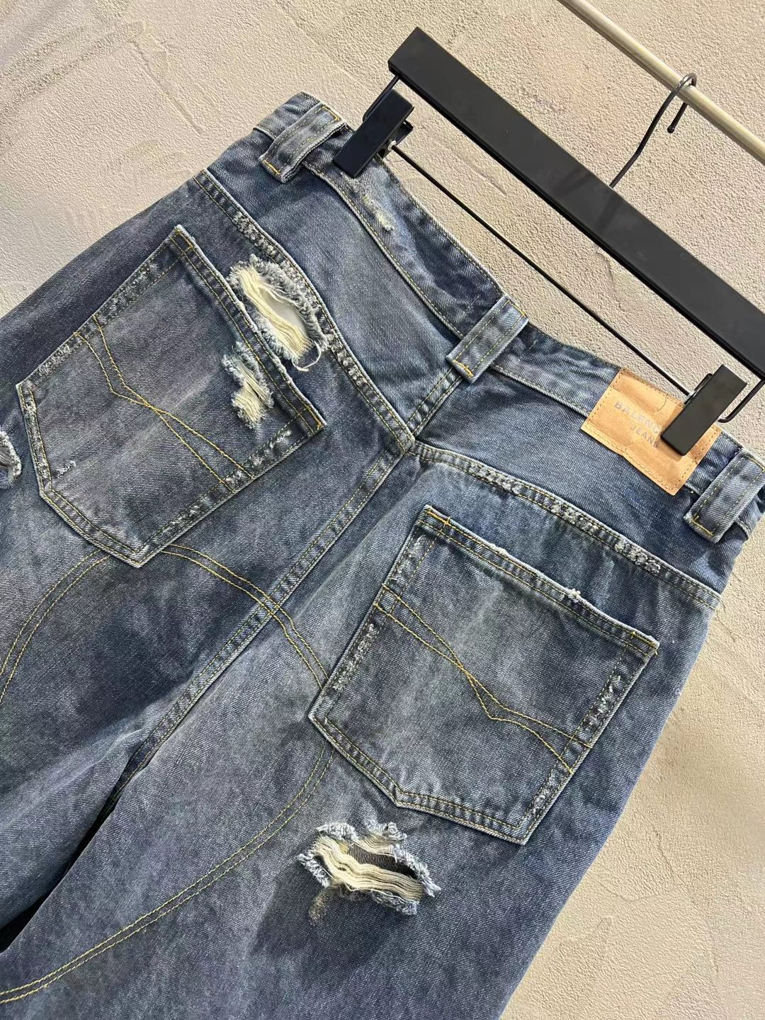 Distressed blue denim shorts with patch pockets, frayed seams, and belt loops