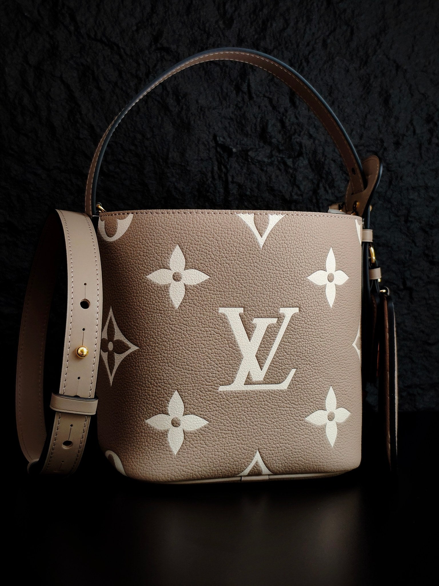 Louis Vuitton monogram bucket bag in light beige with white floral pattern and long shoulder strap