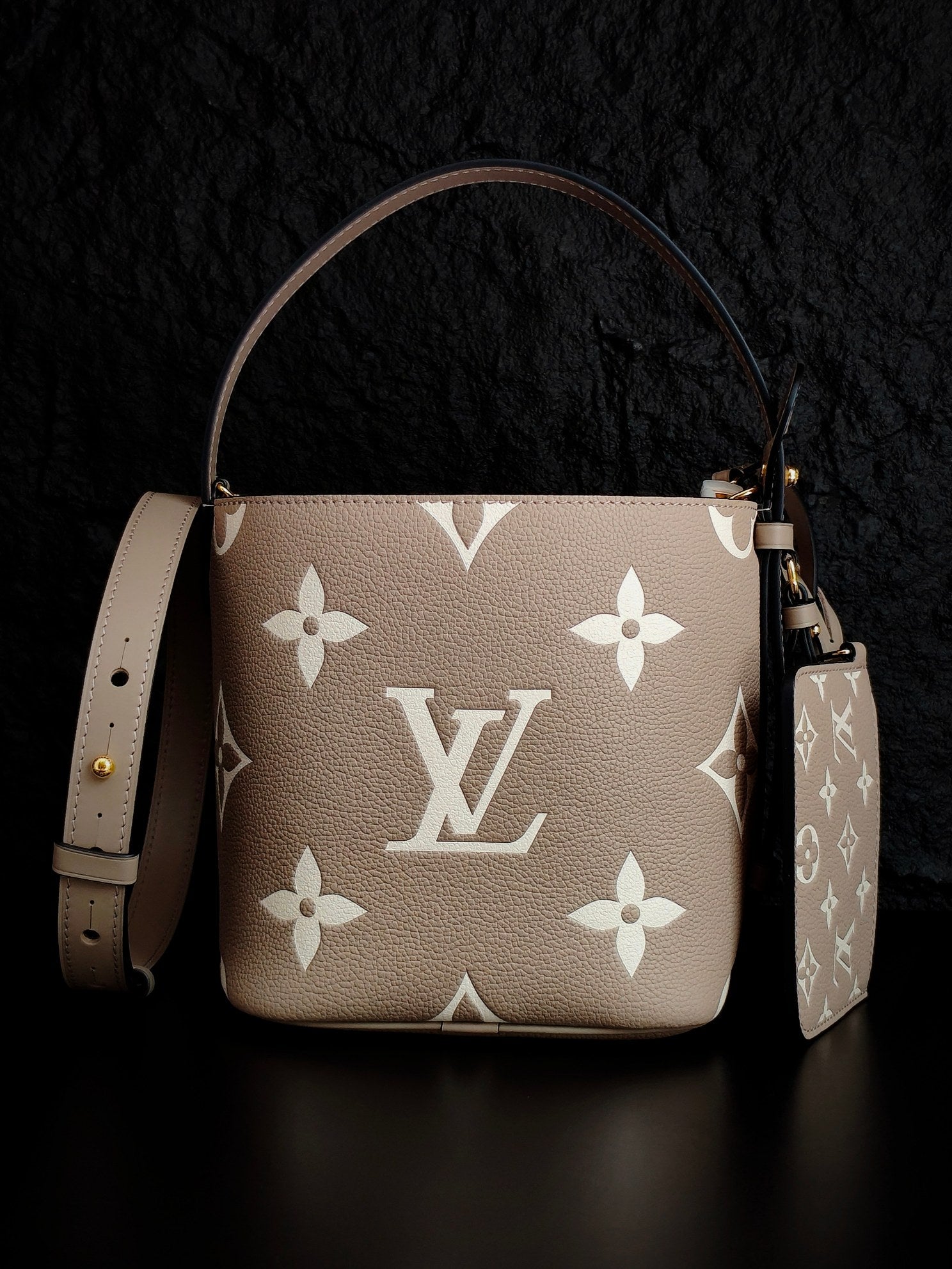 Louis Vuitton monogram bucket bag, light beige with repeating white floral logos, shoulder strap