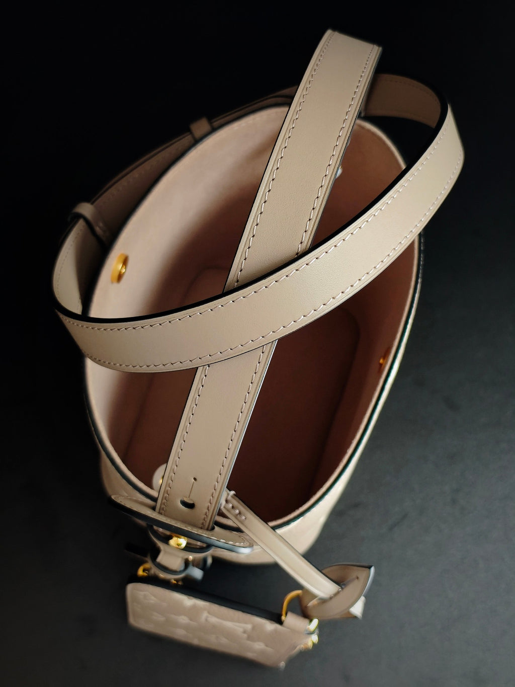 Louis Vuitton monogram bucket bag interior view, light beige exterior with long strap