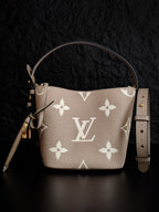 Louis Vuitton monogram bucket bag in light beige with white floral pattern, top handles