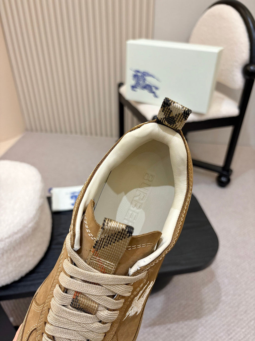 Tan suede sneaker showing check-pattern lining and fabric lace-up