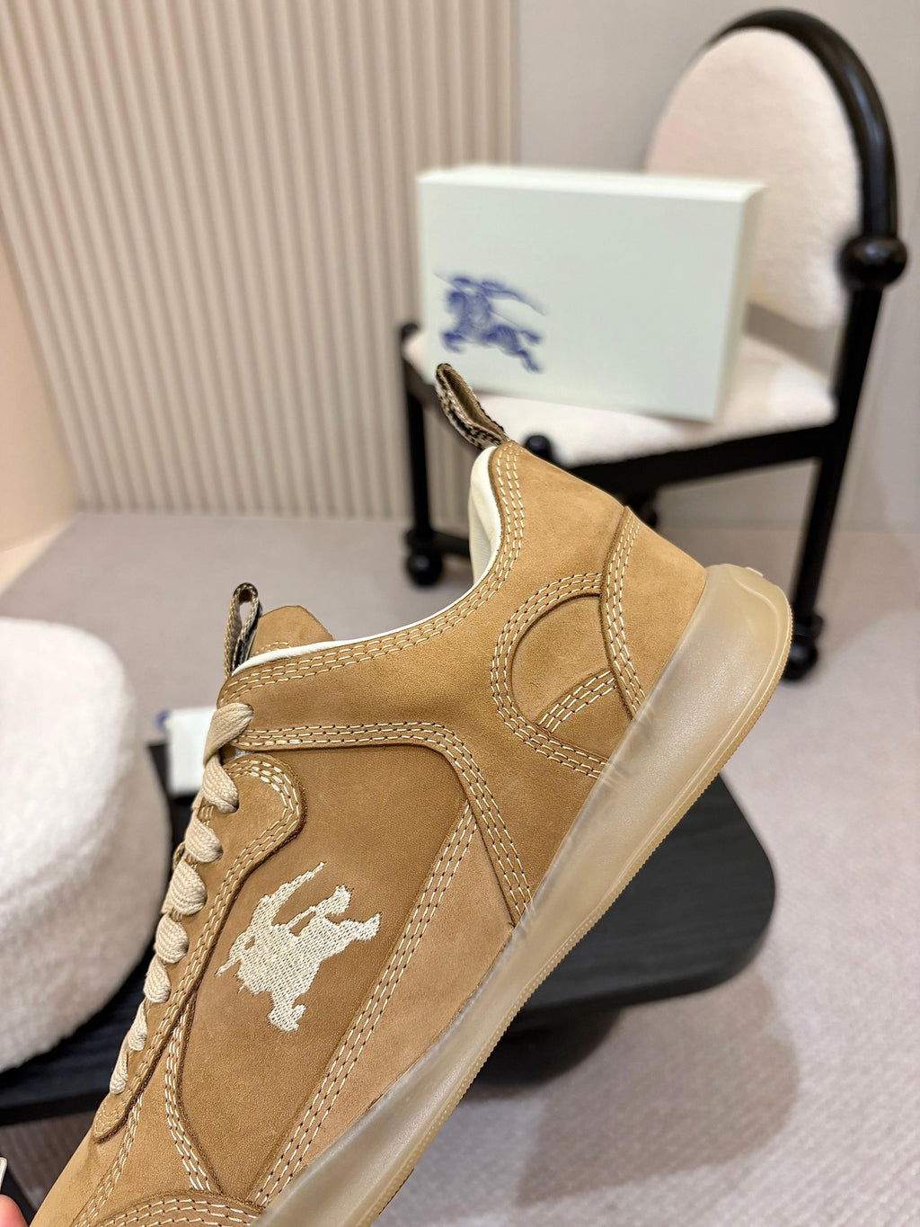Tan suede sneakers with white horse logo and contrasting light sole, side view