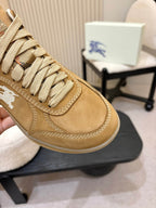 Close-up of tan suede sneaker upper with white horse logo and stitched lacing