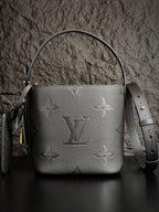 Louis Vuitton monogram bucket bag in gray with top handle and detachable strap