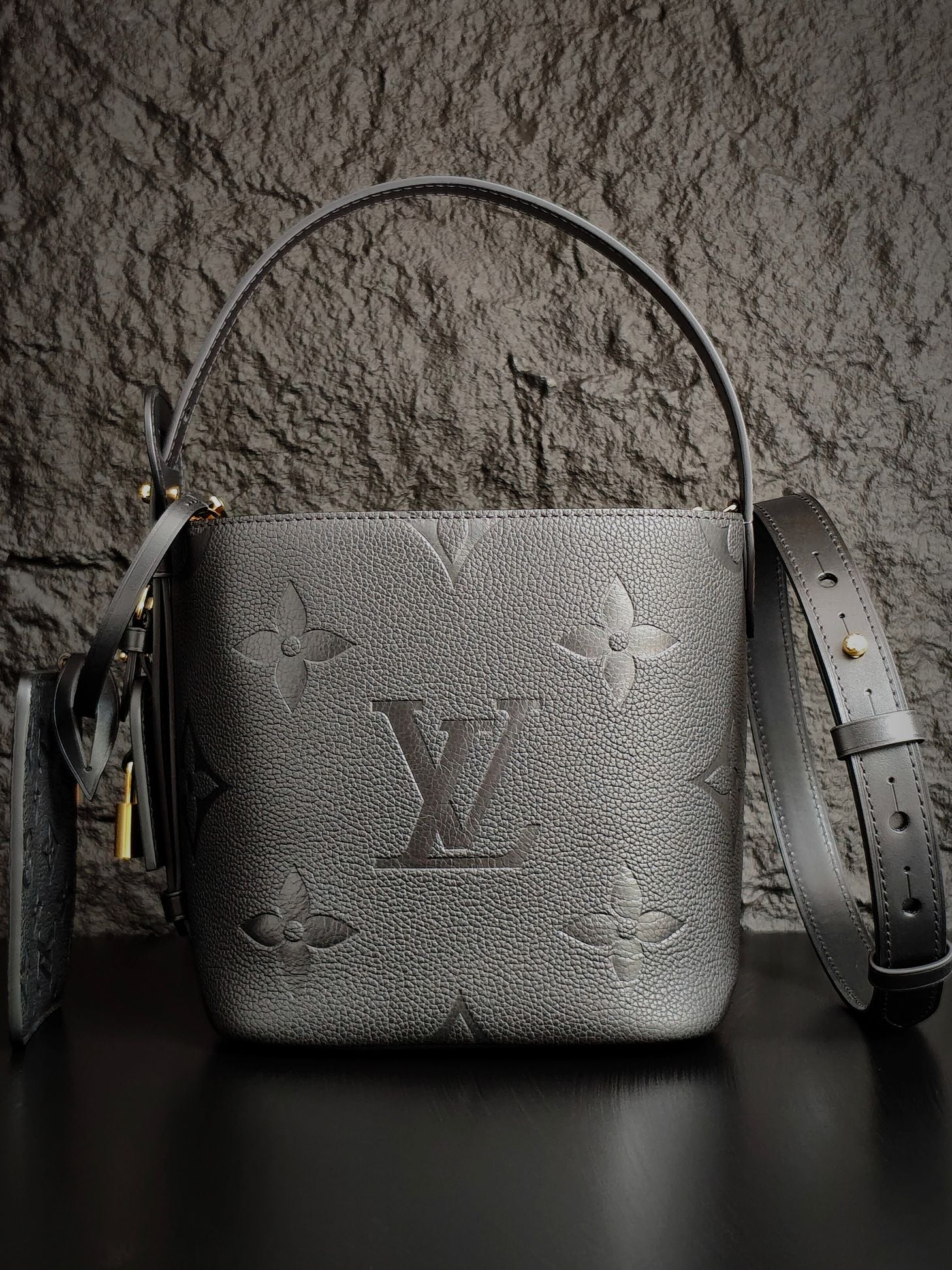 Louis Vuitton monogram bucket bag in gray with top handle and detachable strap
