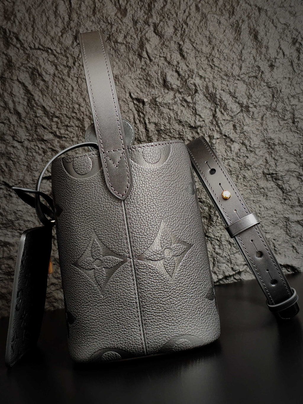 Louis Vuitton monogram bucket bag in gray with vertical seams and leather straps